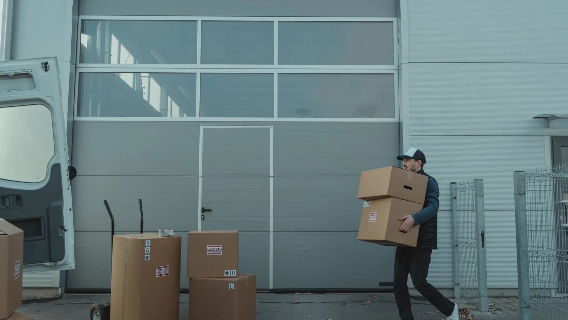 Worker carrying boxes out of a residential basement during a cleanout