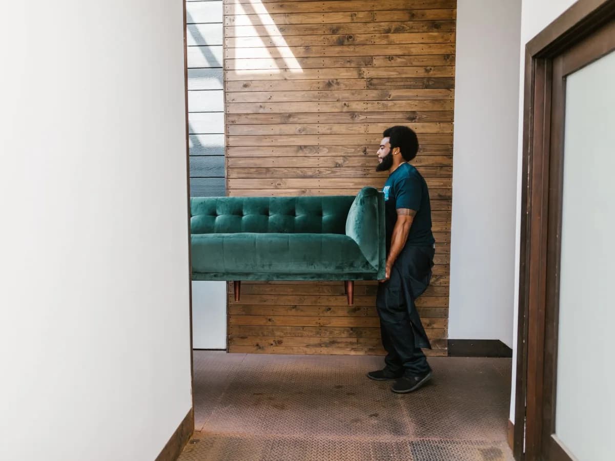 Bulky sofa being moved up a narrow basement staircase