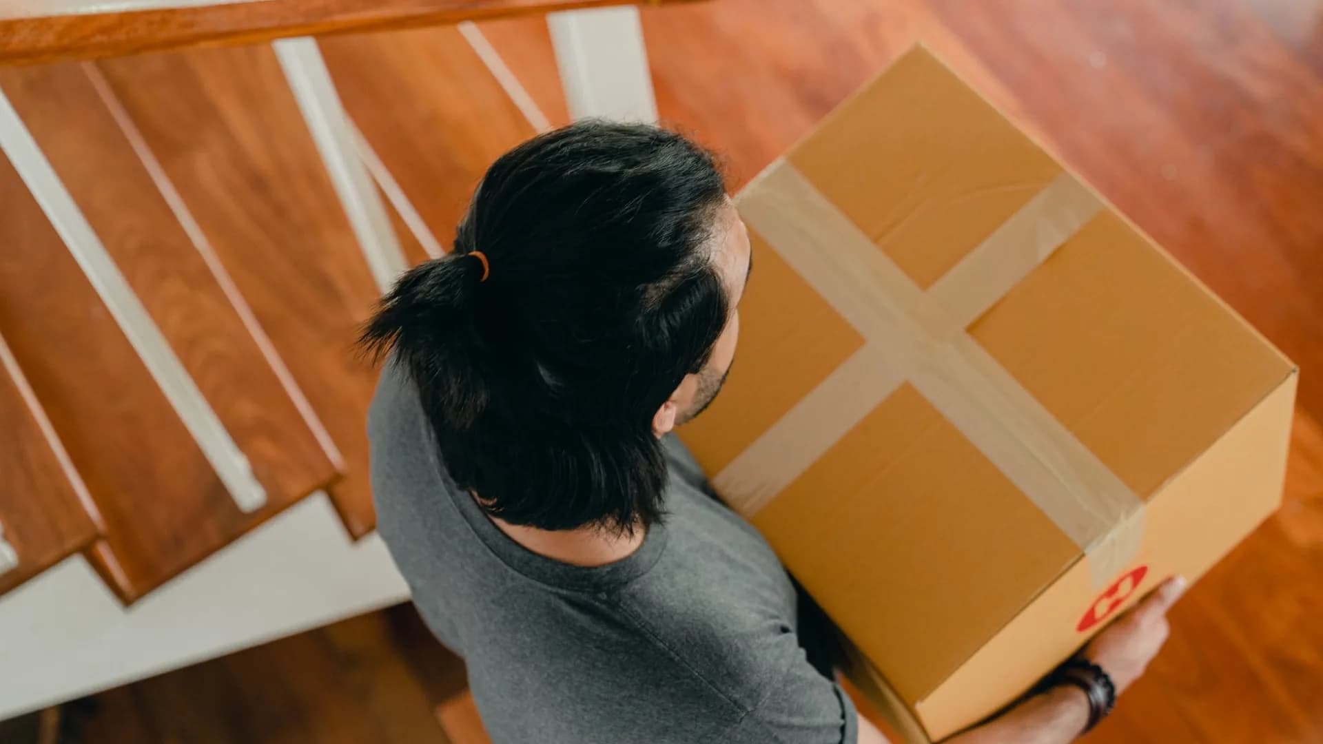Worker carrying a box up basement stairs during a residential cleanout