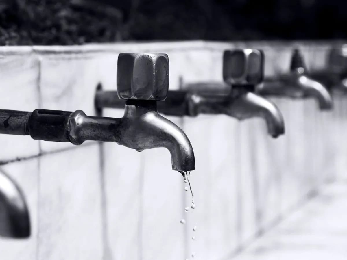 Close-up of a dripping faucet showing water damage