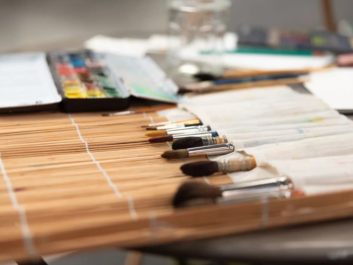 A collection of painting supplies scattered on a workbench, ready for a touch-up.