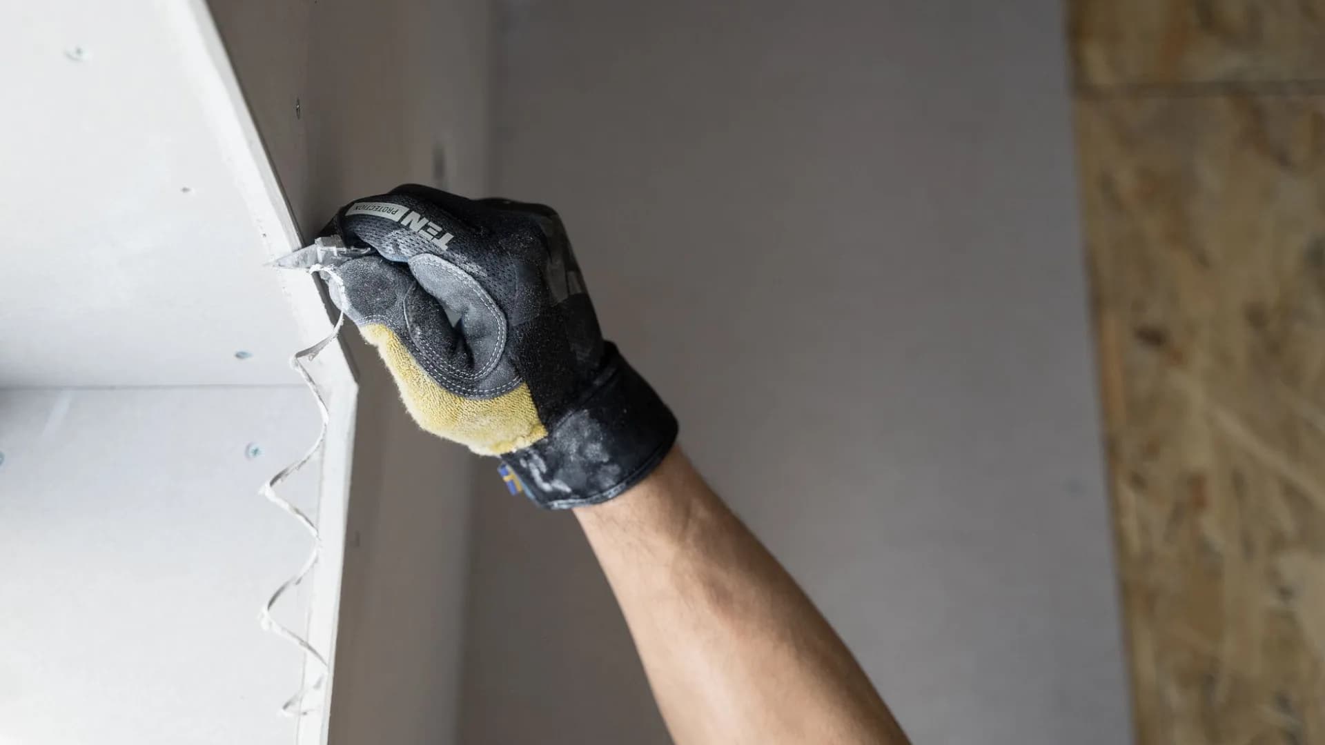 Homeowner repairing drywall hole in a living room