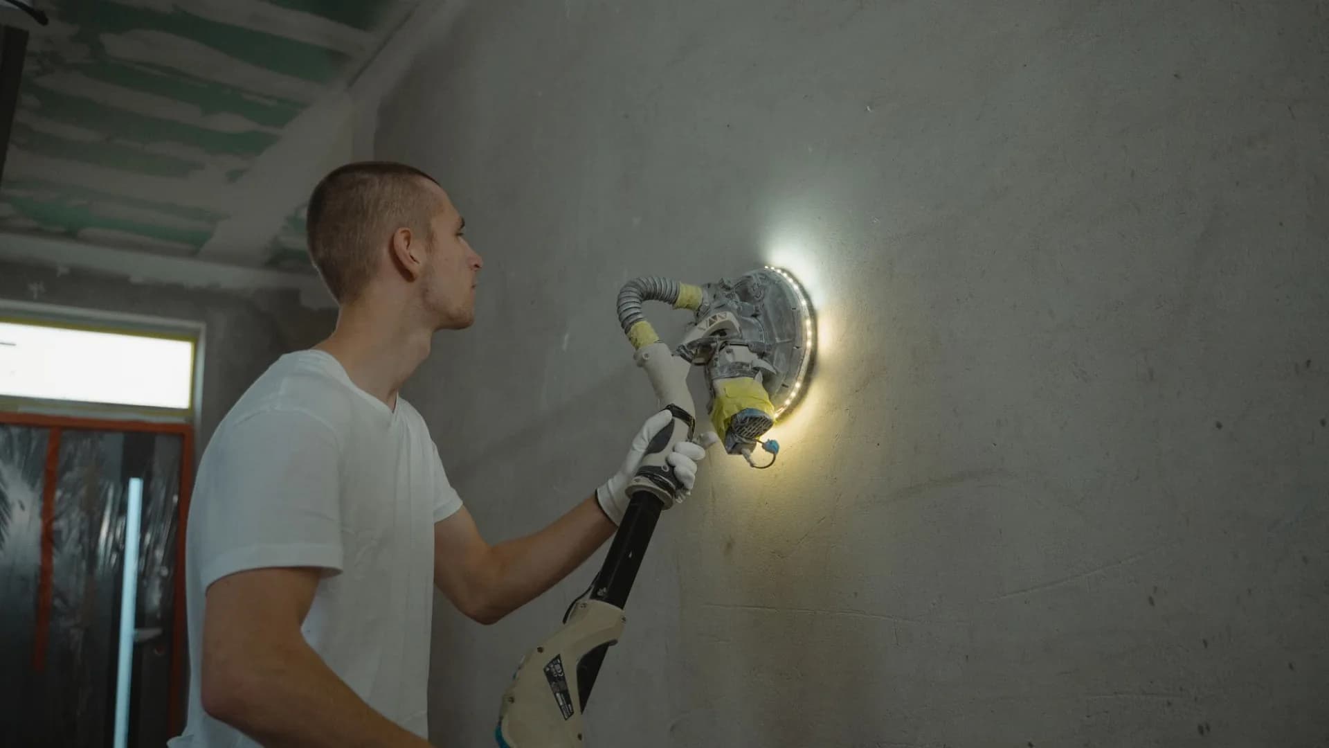 A worker repairing drywall in a condo