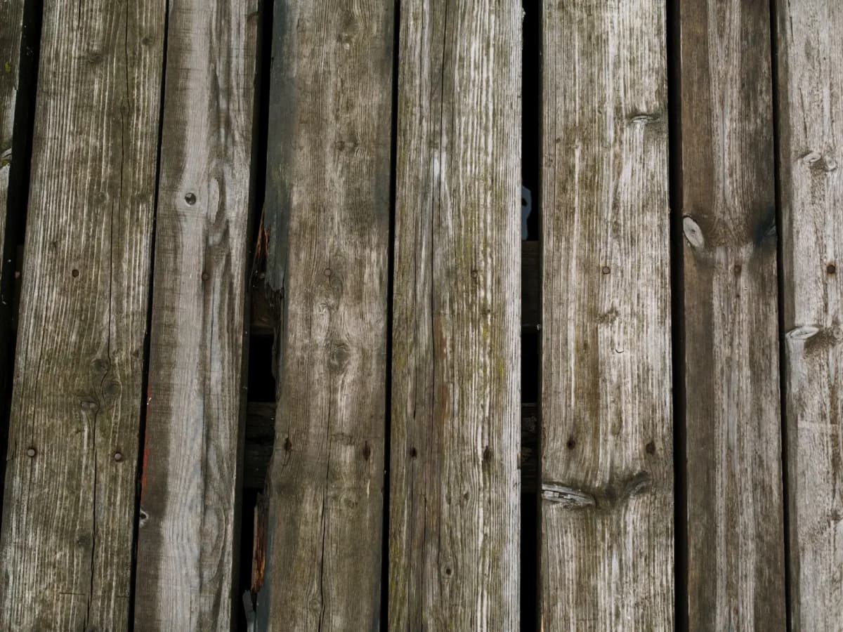 Damaged wooden deck planks needing repair.
