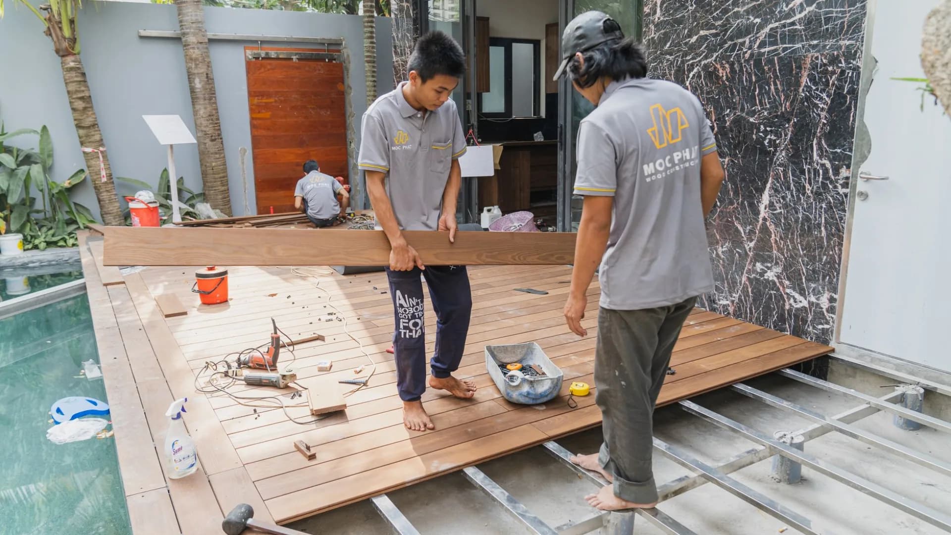 Worker repairing a wooden deck in a residential setting