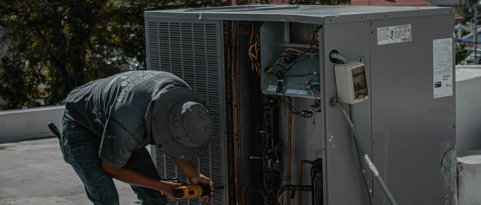 AC technician repairing air conditioning unit