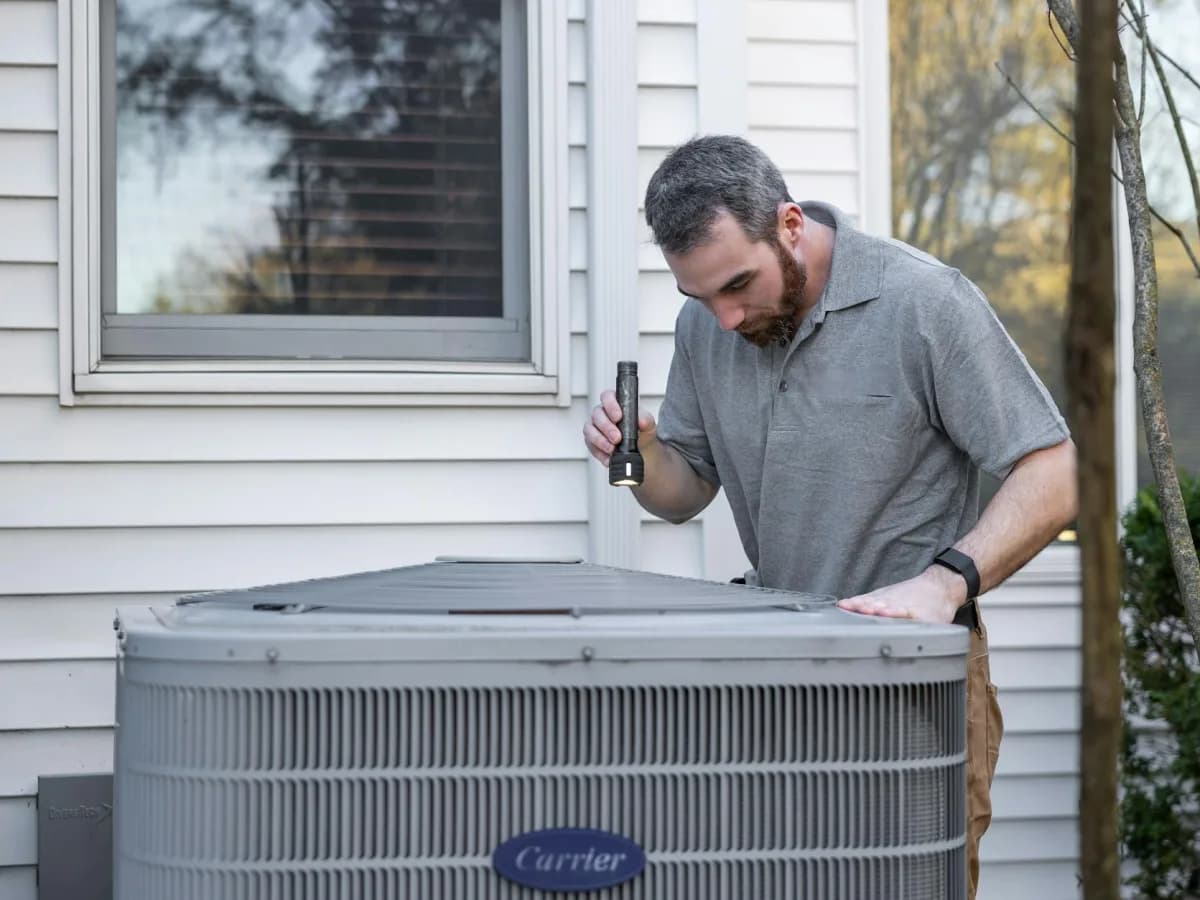 Homeowner checking air conditioner filter