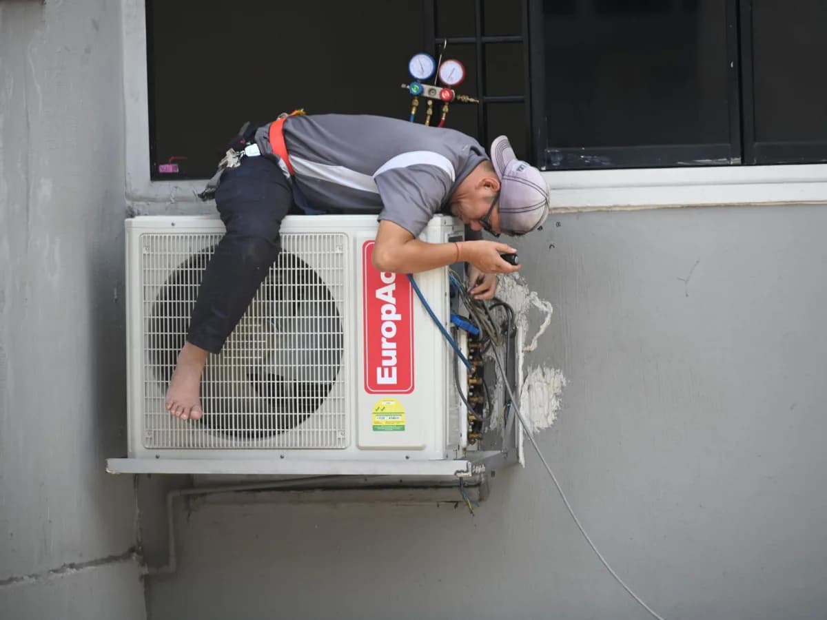 HVAC technician servicing air conditioning unit