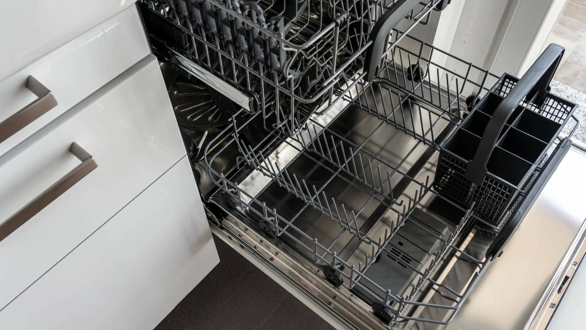 Installer working on dishwasher in kitchen