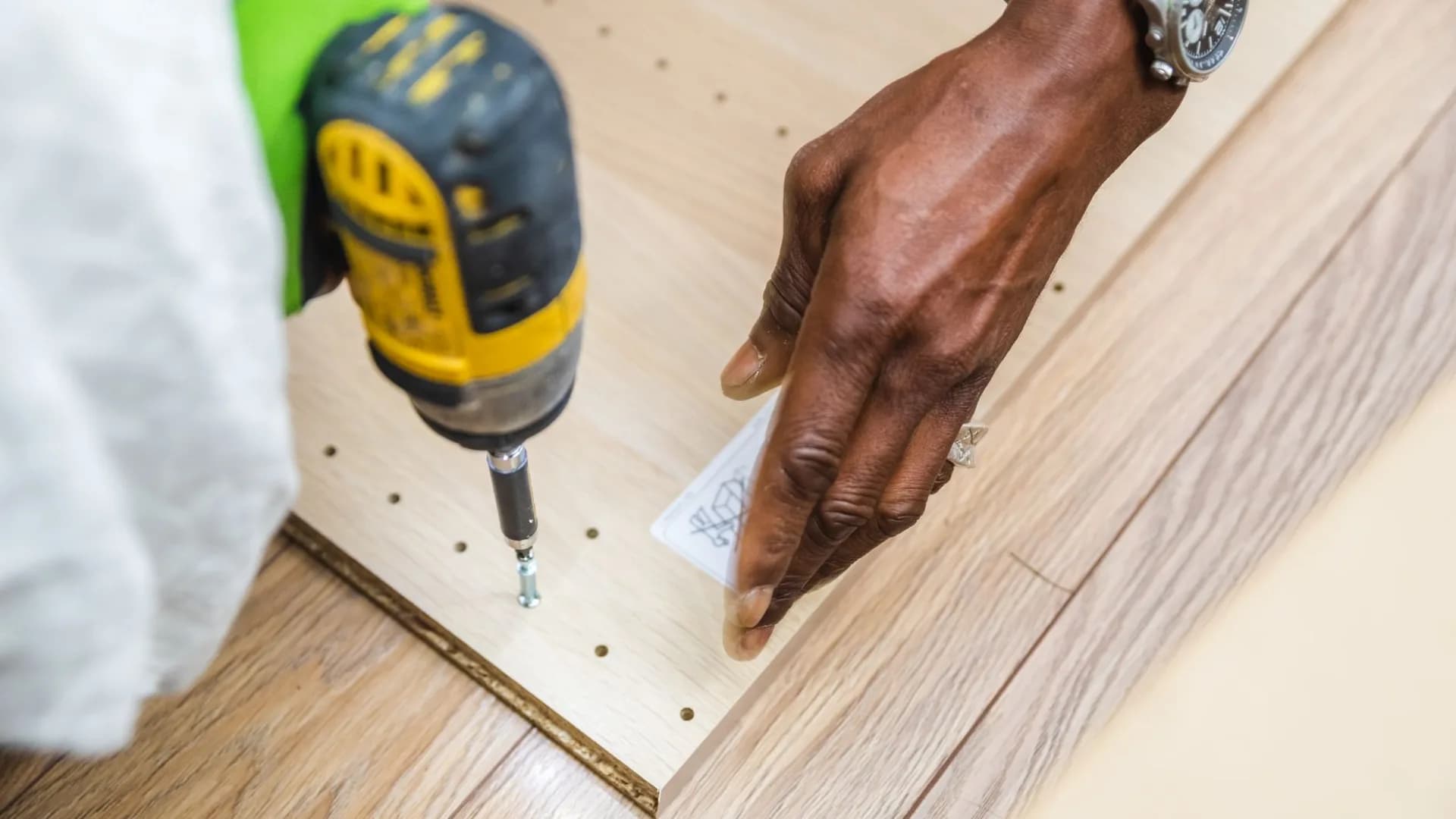 Professional assembling a shelving unit in a residential living room