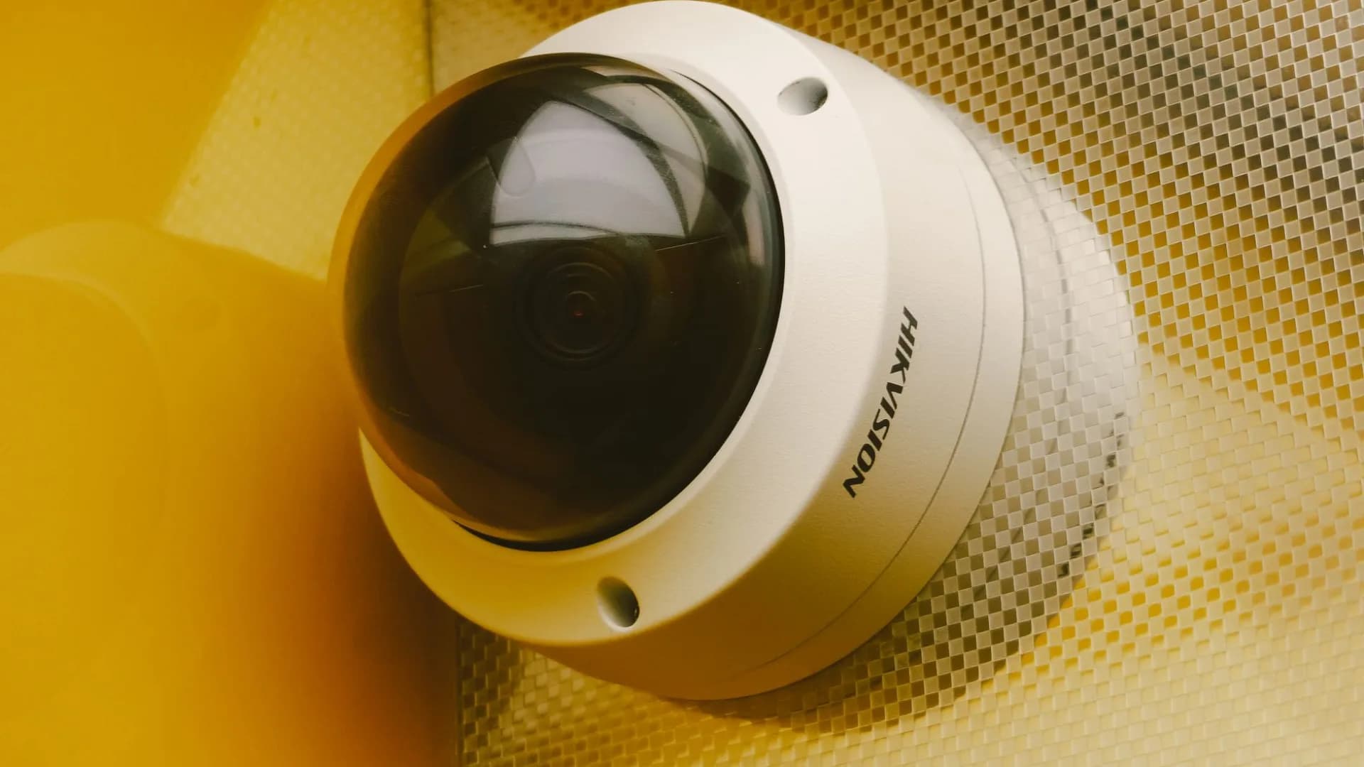 Technician installing a security camera on a residential home