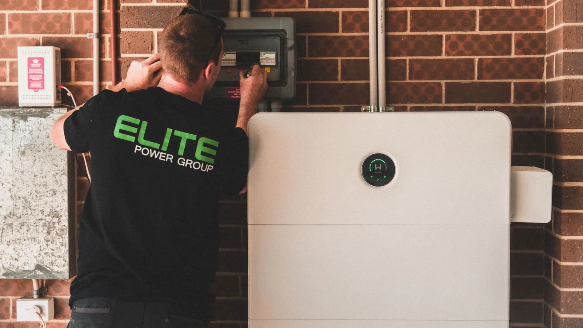 Technician installing a security camera on a house
