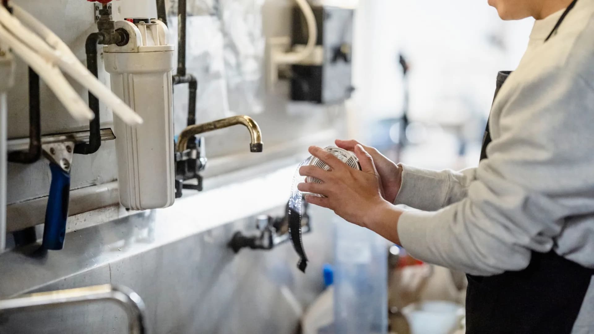 Technician fixing a leaky kitchen sink