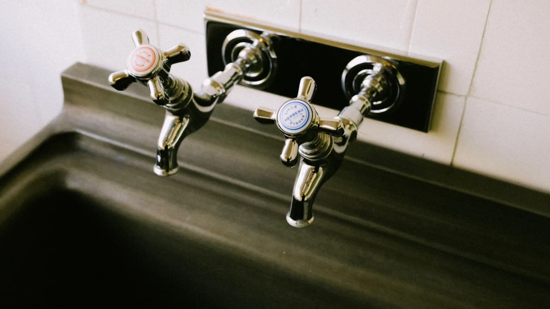 Technician repairing sink in kitchen