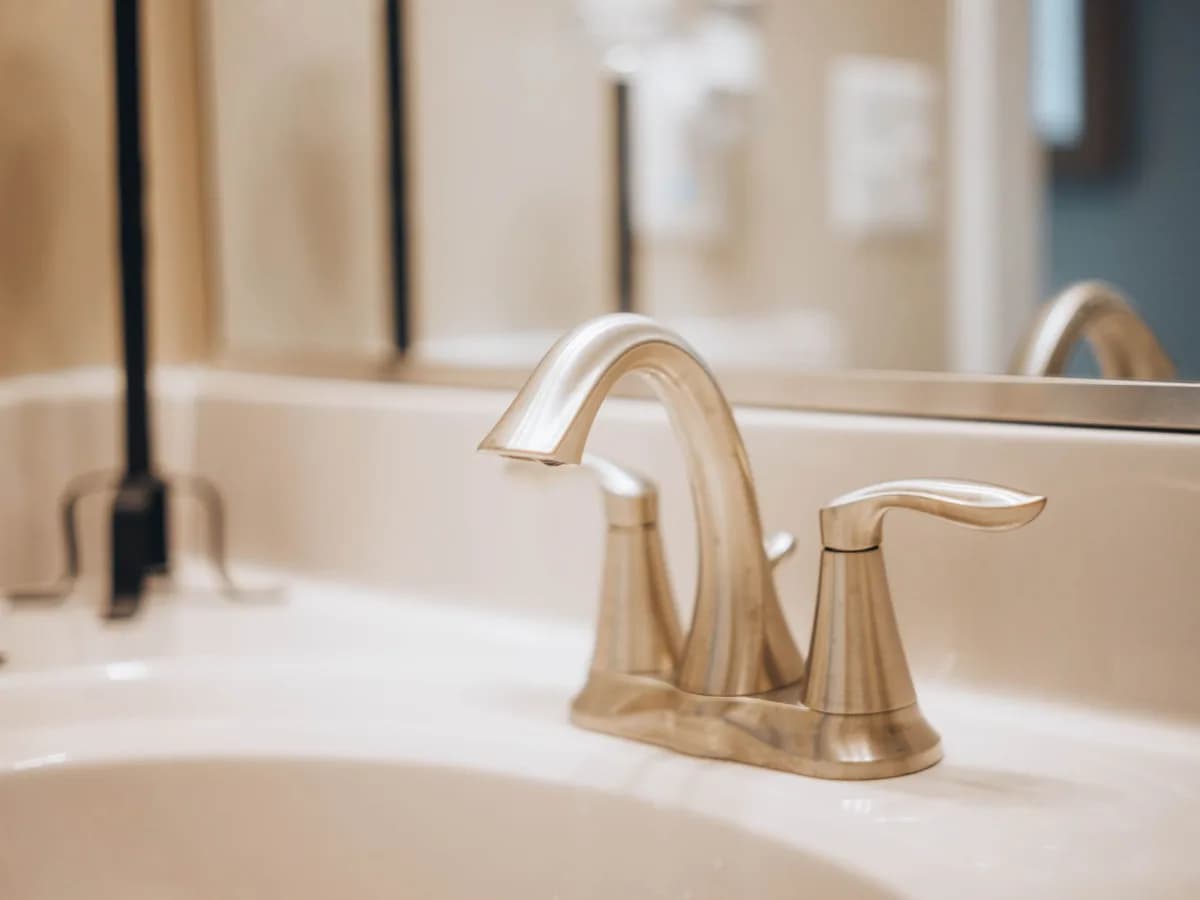 Close-up of a leaky bathroom faucet showing damage.