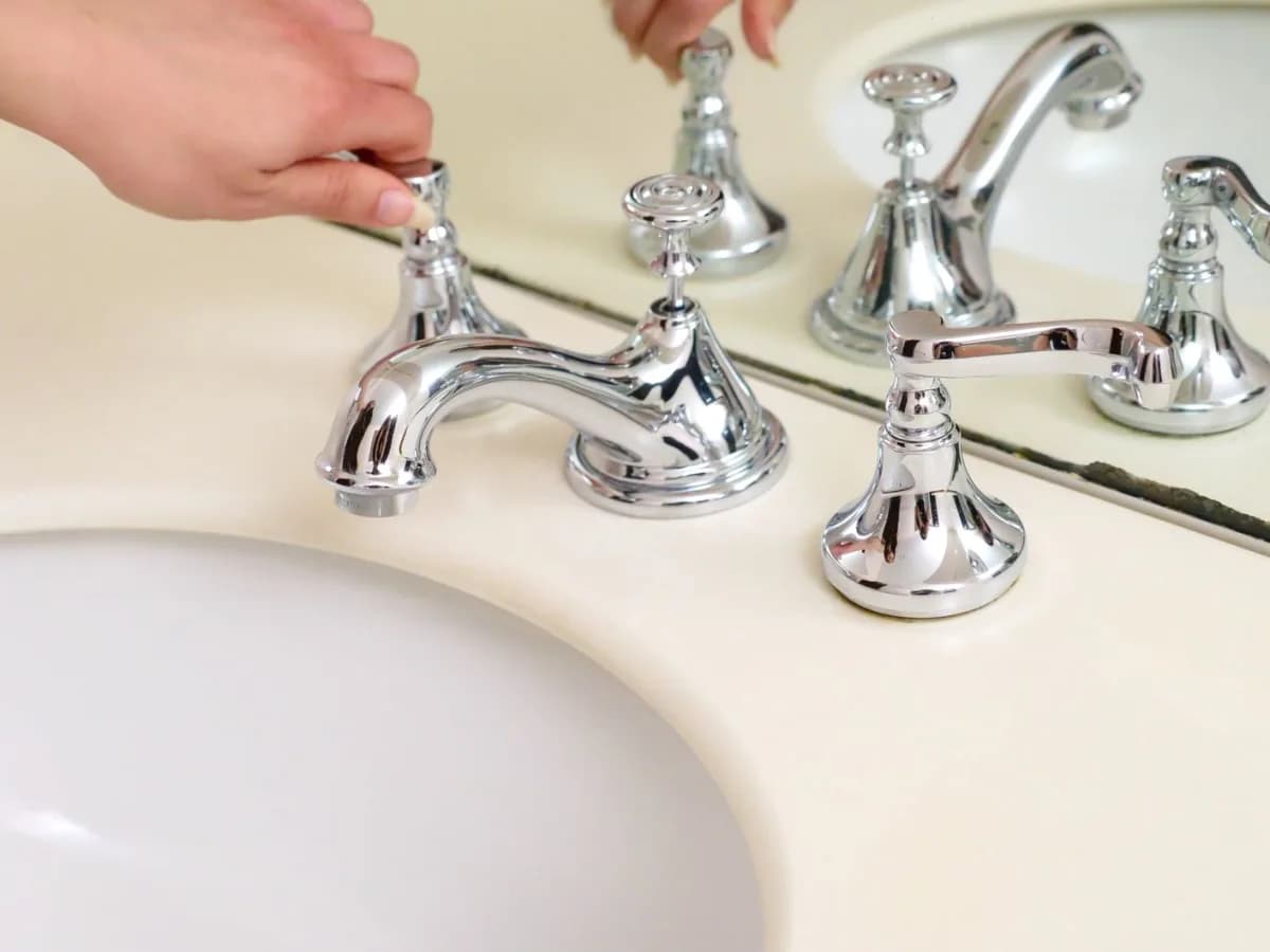 Professional assessing a faucet leak in the bathroom
