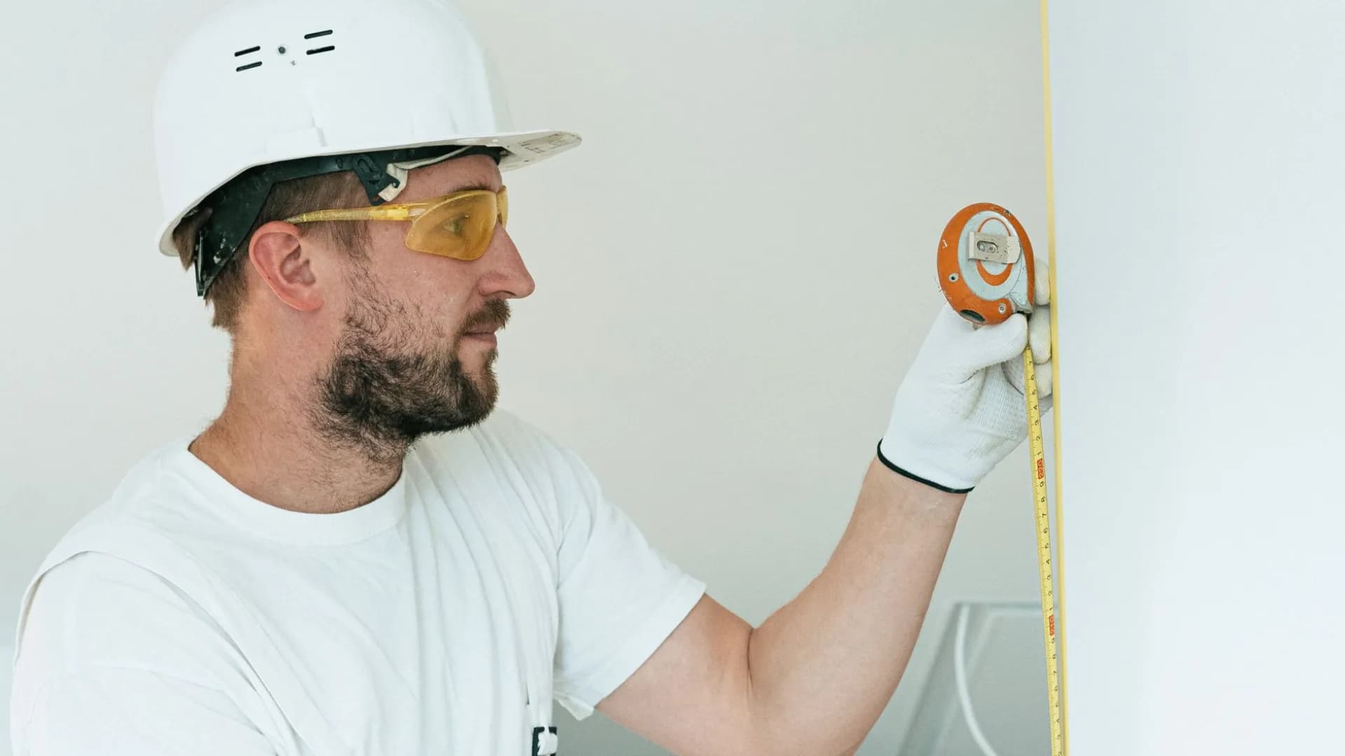 Contractor applying caulk to bathtub