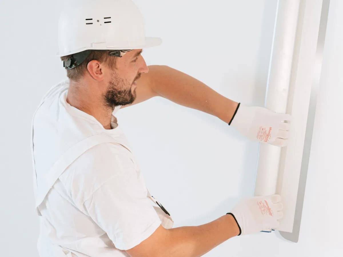 Professional handyman working on bathtub caulking repair.