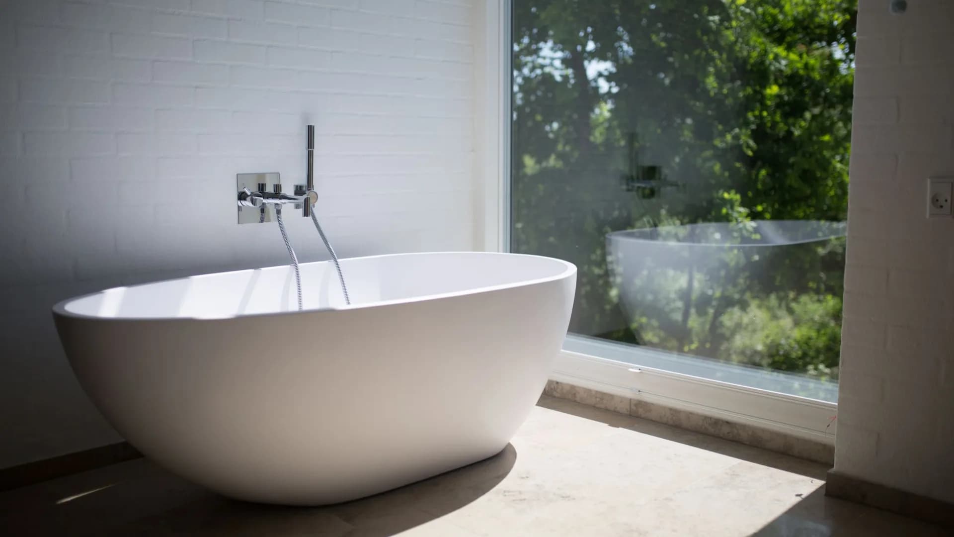 Professional applying caulk around bathtub