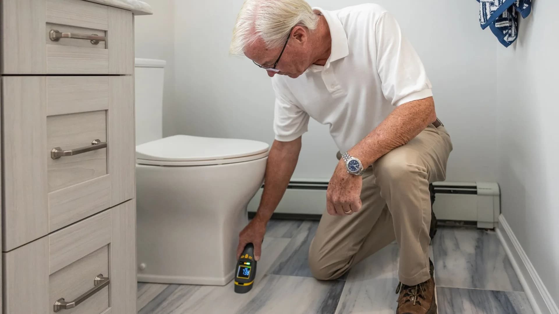Plumber diagnosing toilet issue in residential bathroom