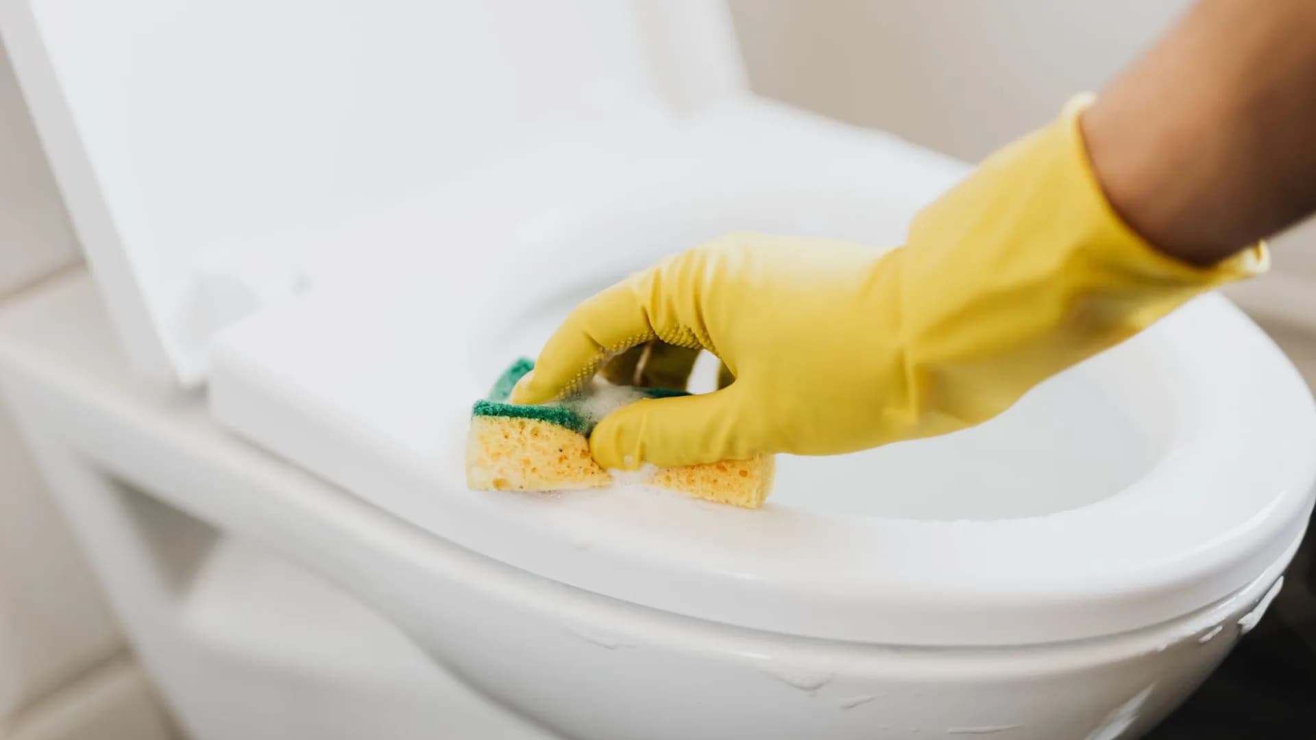 Technician repairing a toilet in a modern bathroom