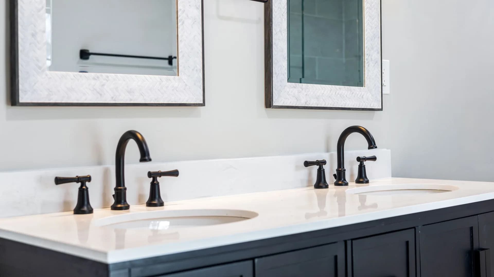 Installer connecting plumbing beneath a new bathroom vanity.