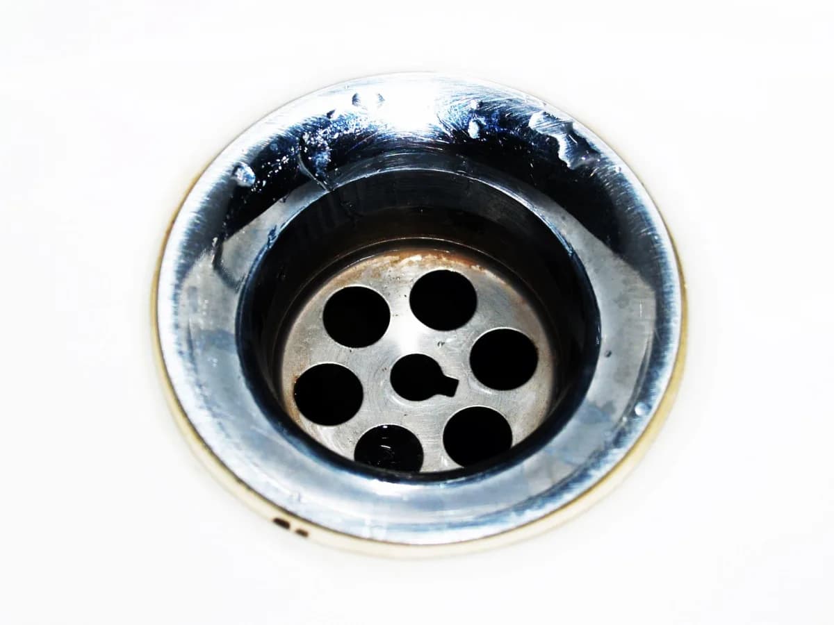Water damage and a small leak inside a bathroom vanity cabinet.
