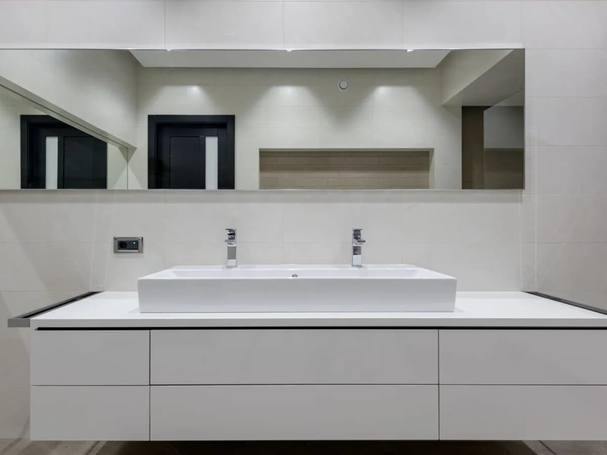 Vanity measurements, faucet hardware, and installation supplies prepared on a bathroom floor.