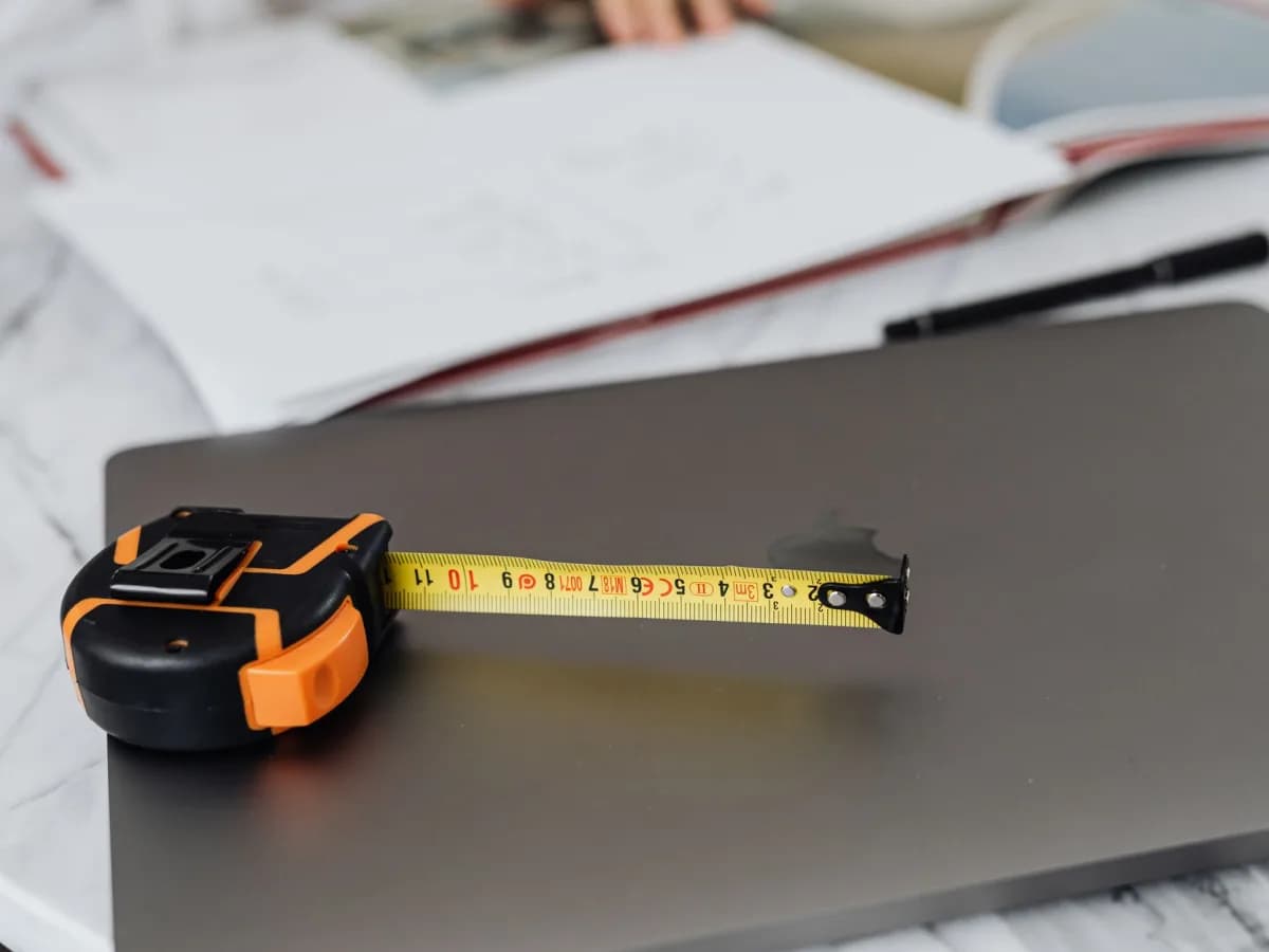 Tape measure and plumbing connections in an empty bathroom vanity space