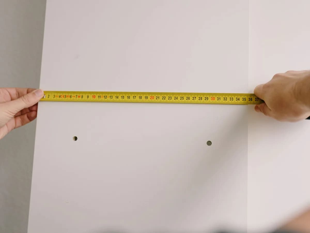 Measuring tape, flashlight, and notes used to document a cracked kitchen backsplash.