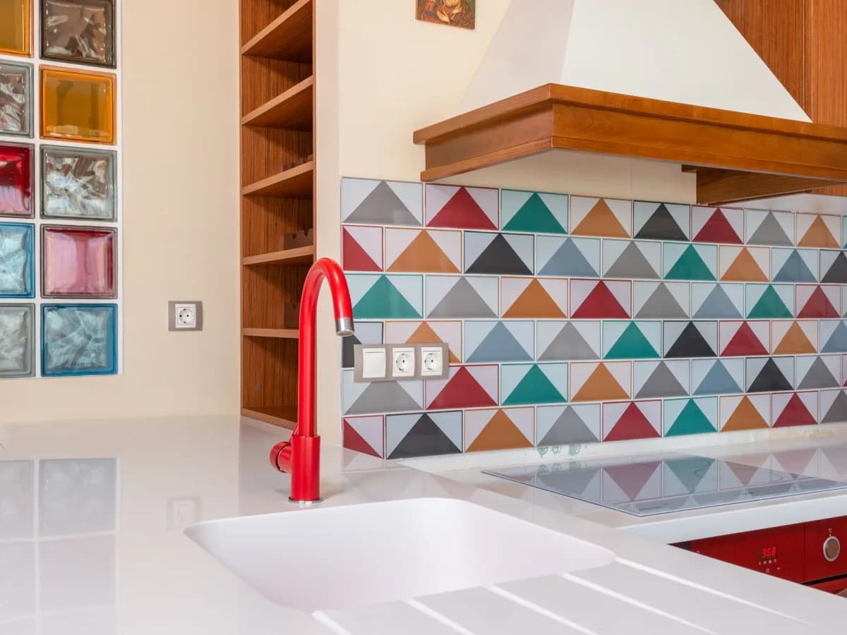 Backsplash tile samples, grout options, spacers, and edge trim arranged on a kitchen counter