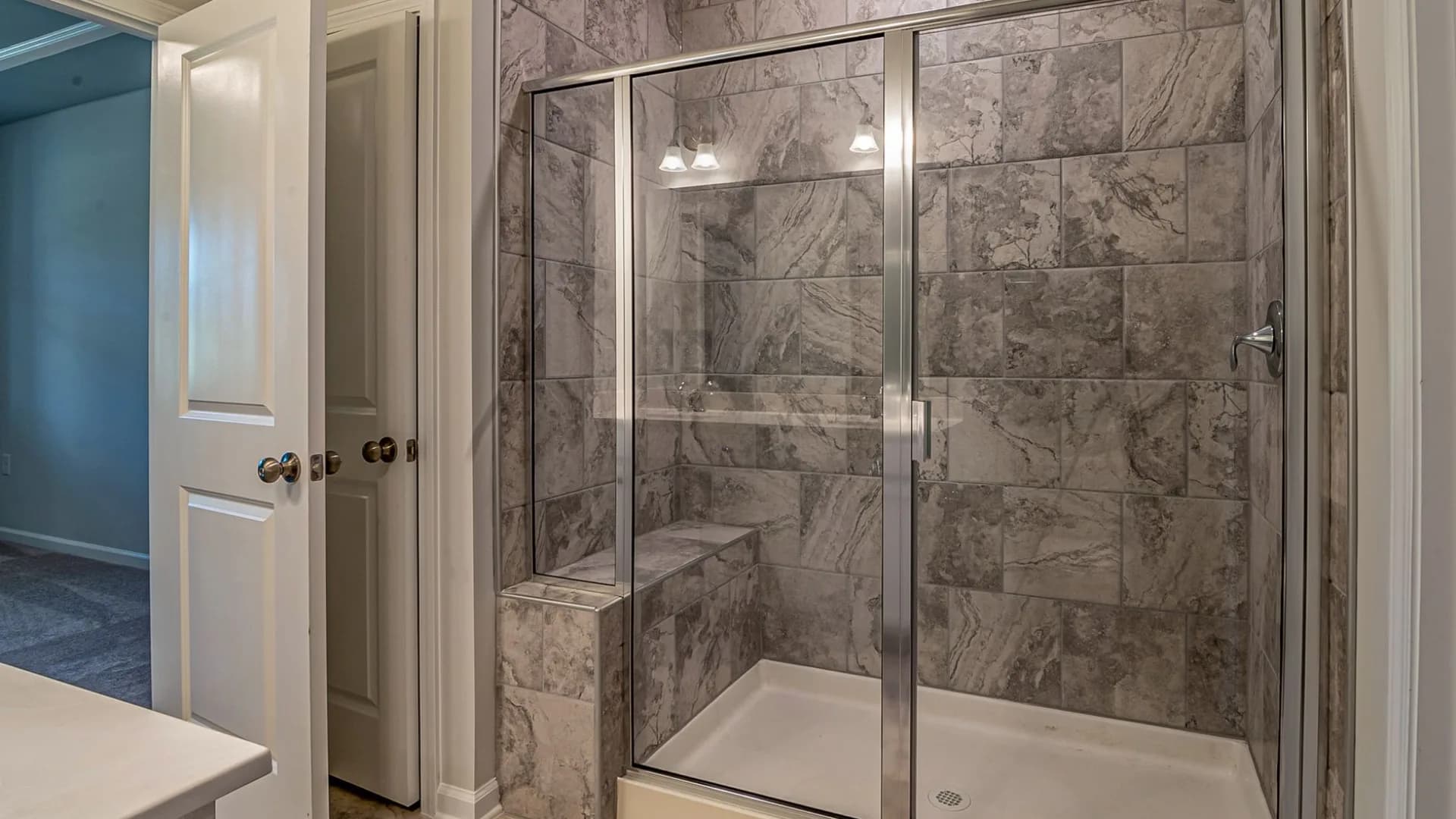 Professional installing a shower door in a residential bathroom.