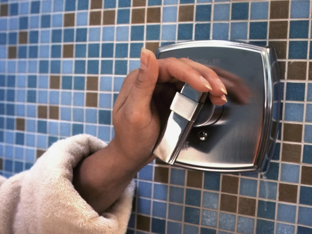 Homeowner performing maintenance on shower door