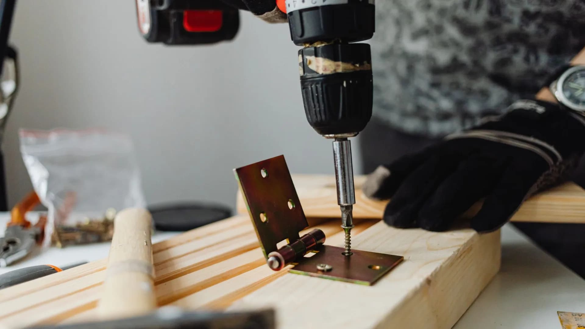 Technician adjusting a concealed hinge on an upper kitchen cabinet door.