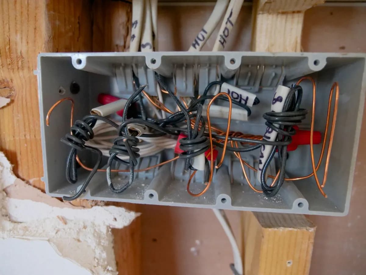 Bathroom electrical and exhaust fan work underway behind an open wall