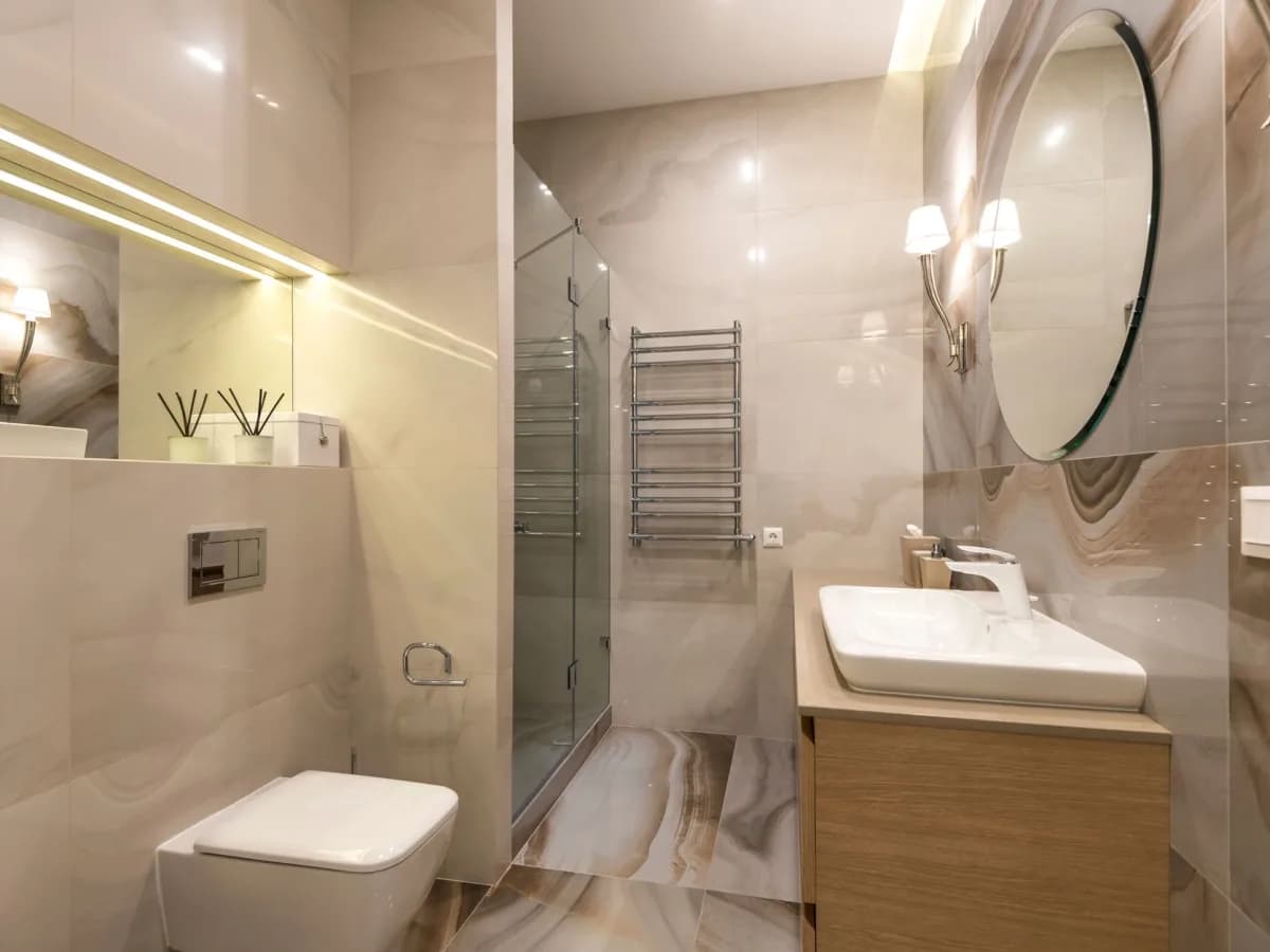 Finished compact bathroom with tiled shower, vanity, and completed fixtures.