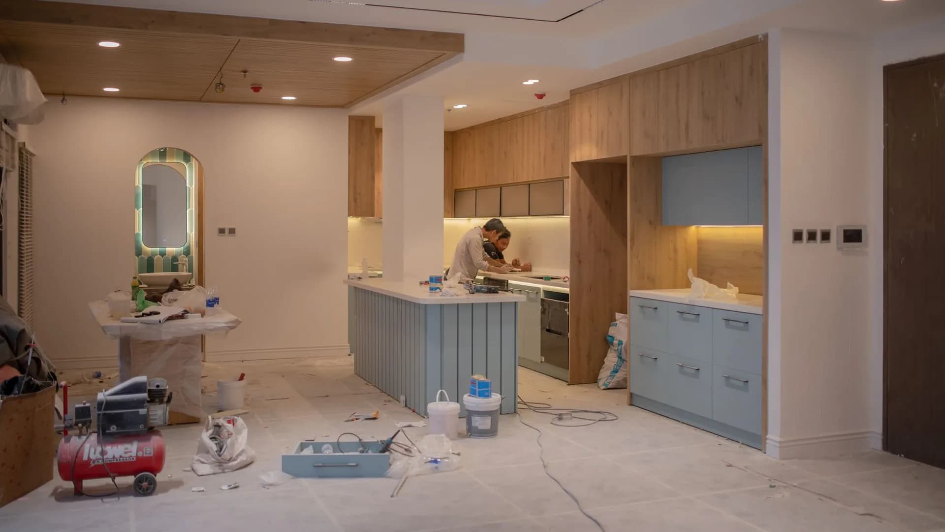 A professional installing kitchen cabinets during a renovation.
